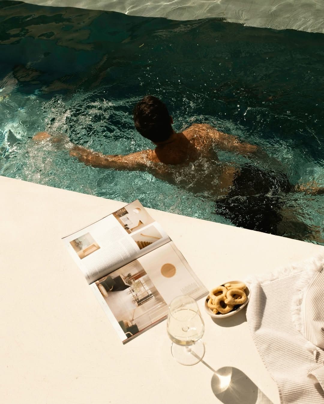 Swimmer by a pool with an open magazine